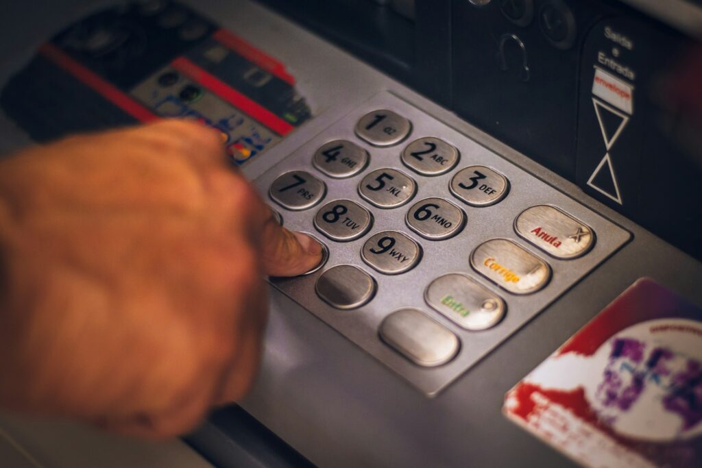 A close-up of a hand pressing buttons on an ATM keypad, preparing to enter a PIN or make a transaction—an ideal moment to Make the Switch for smarter banking.